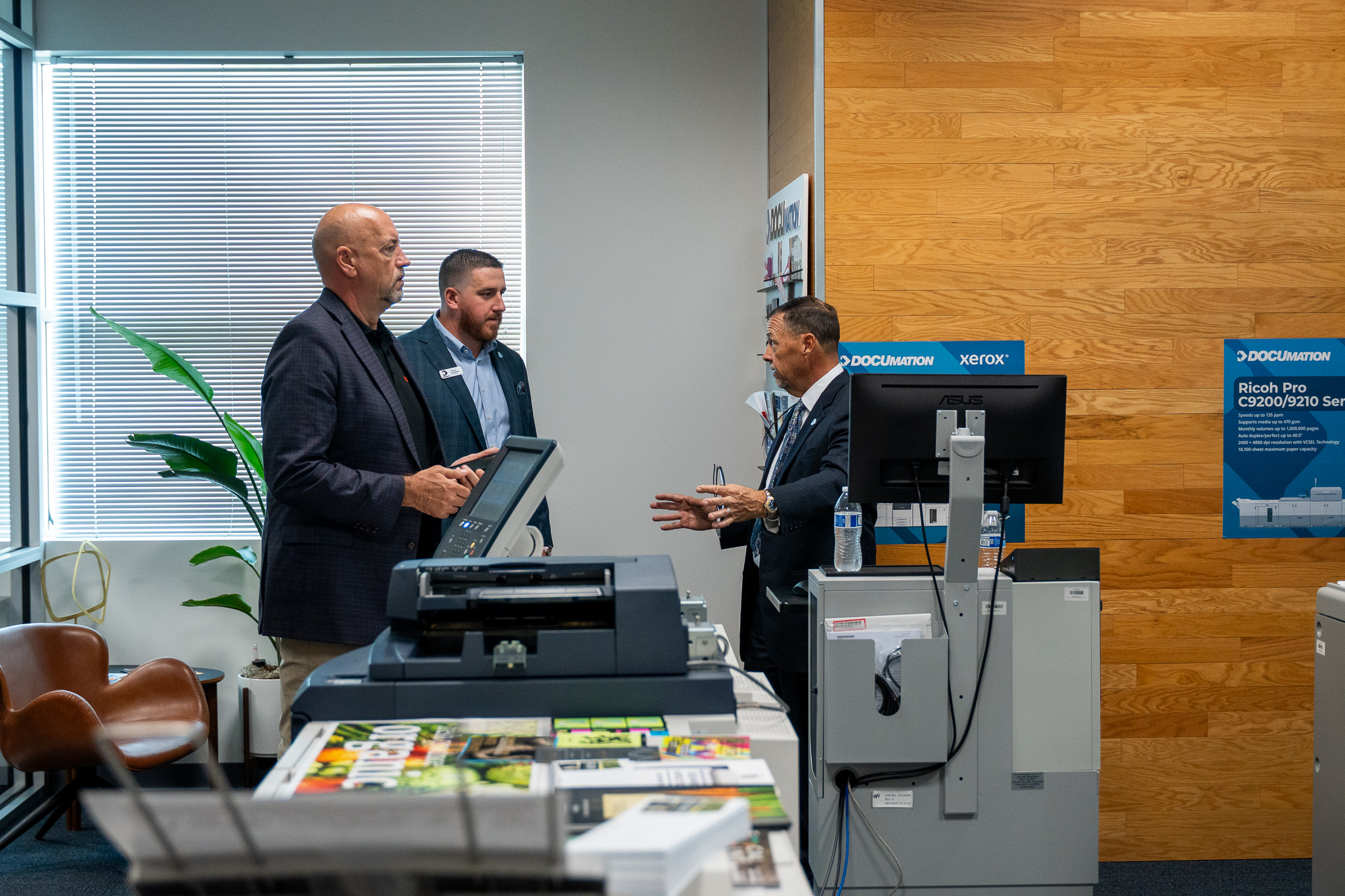 DOCUmation team discussing print technology in a business showroom