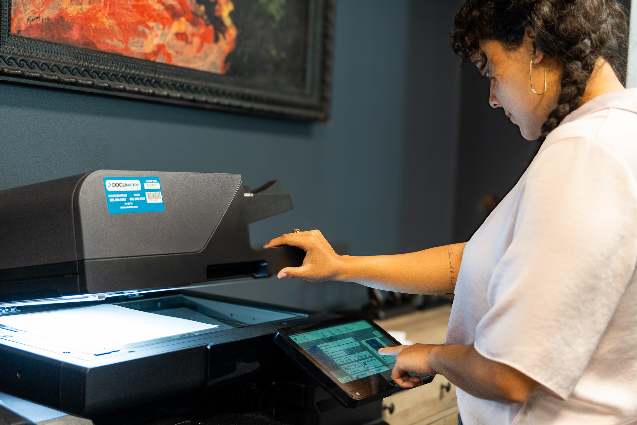 DOCUmation employee operating a multifunction office printer