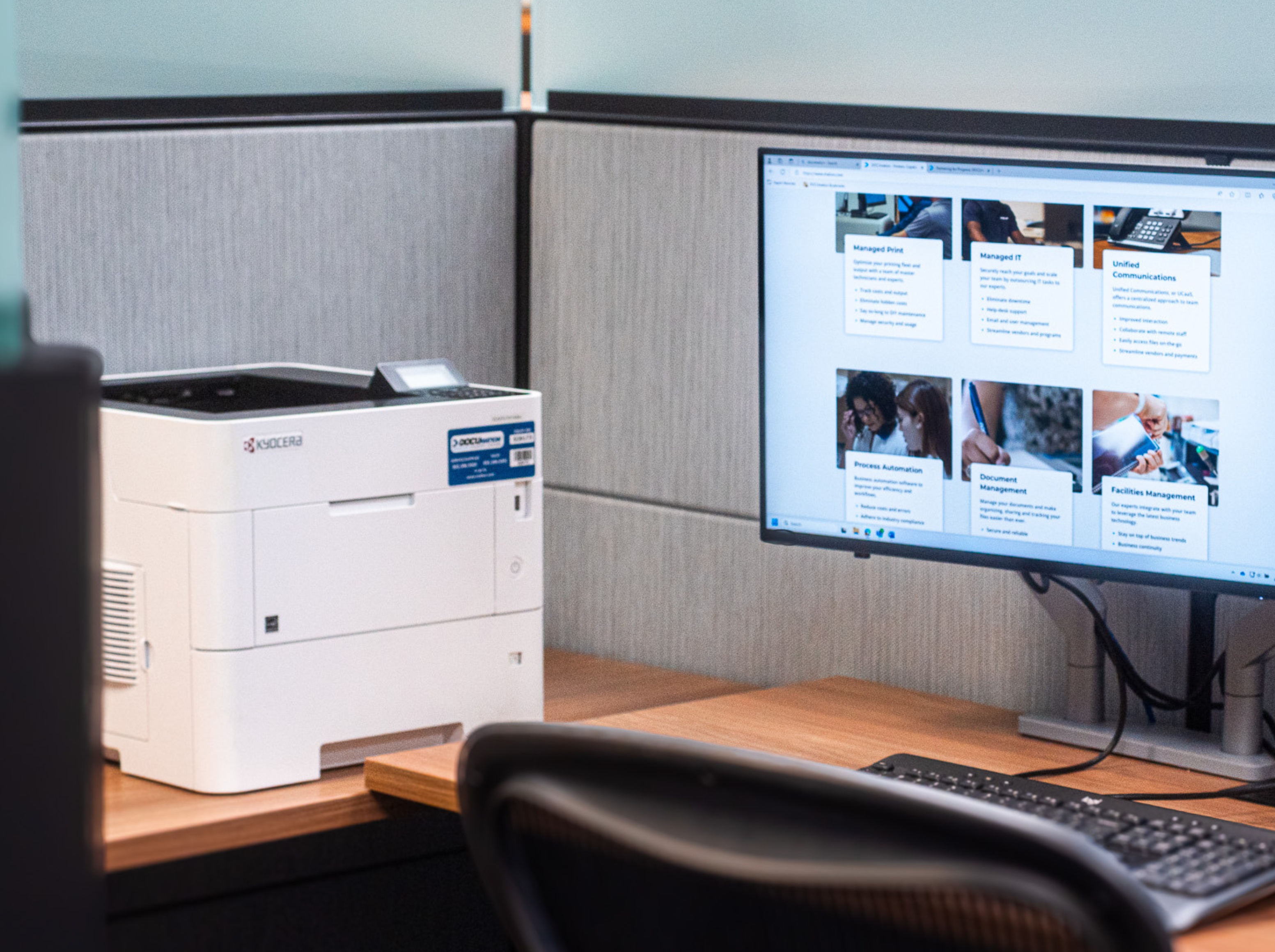 Desk with a Kyocera printer and a desktop computer.