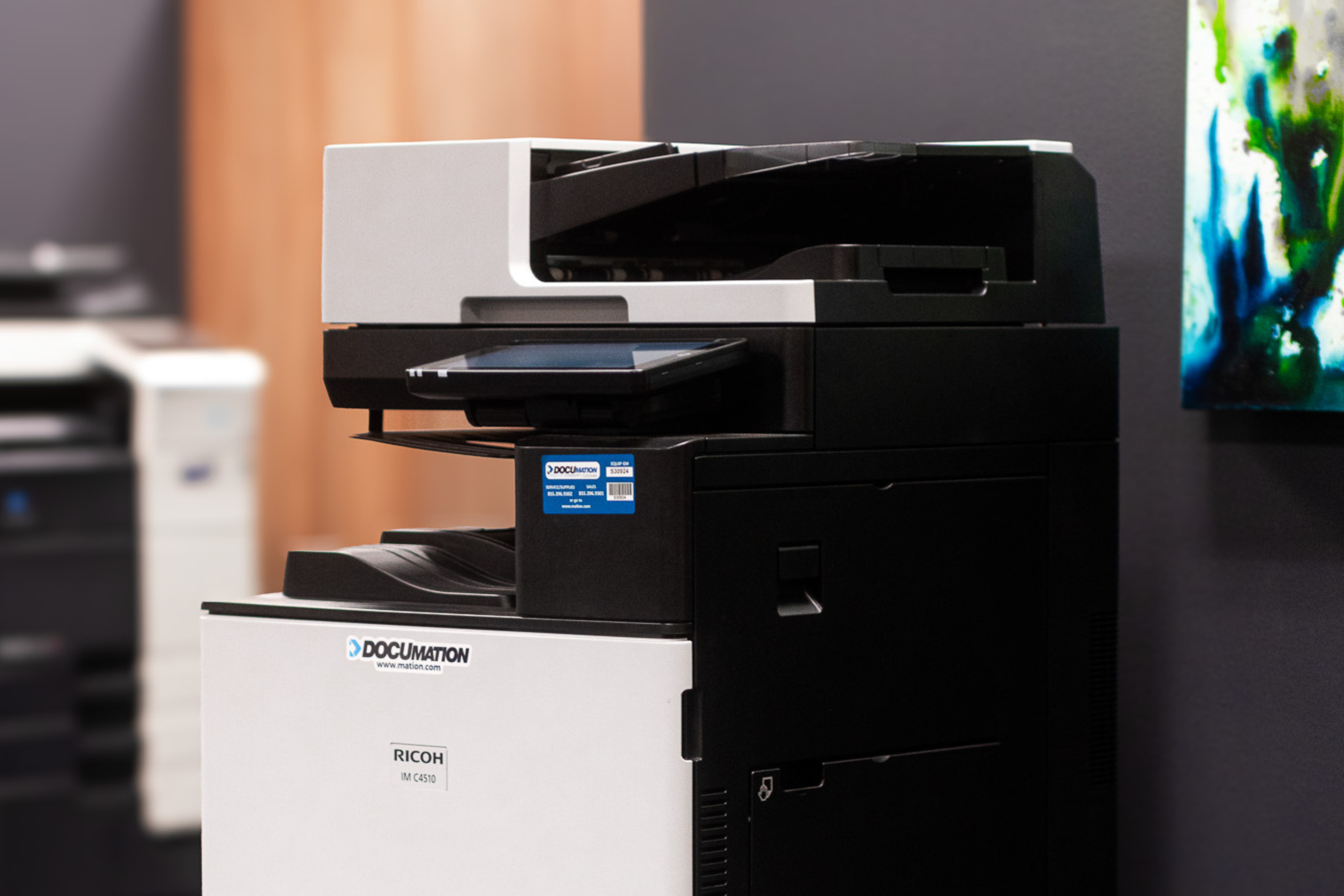Ricoh MFP printer in a modern office setting.