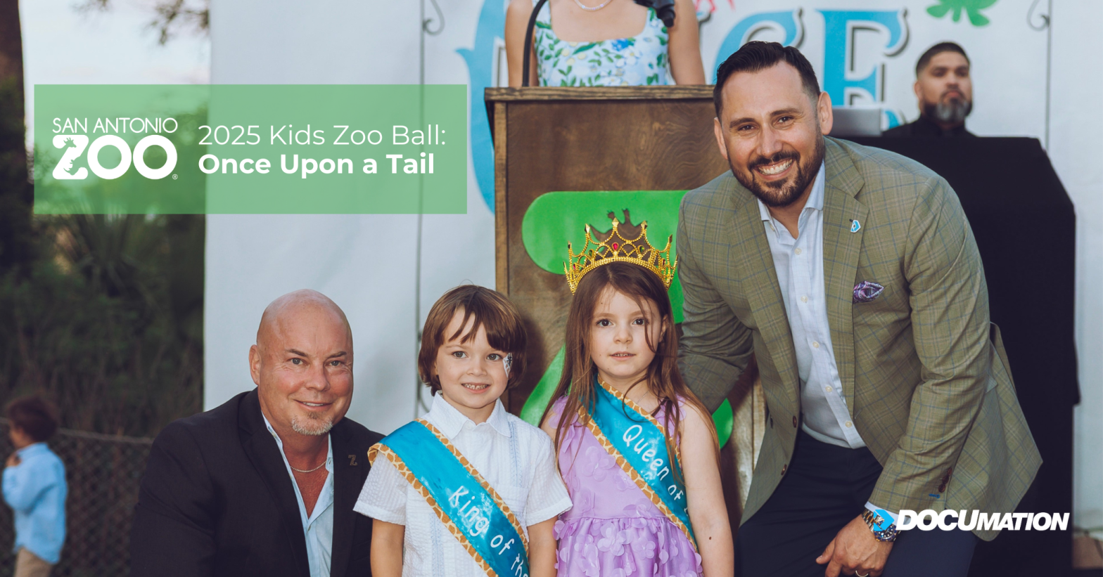 Robby Brown of DOCUmation and Tim Morrow, CEO of the San Antonio Zoo, pose with two children dressed as king and queen at the 2025 Kids Zoo Ball, themed “Once Upon a Tail.”