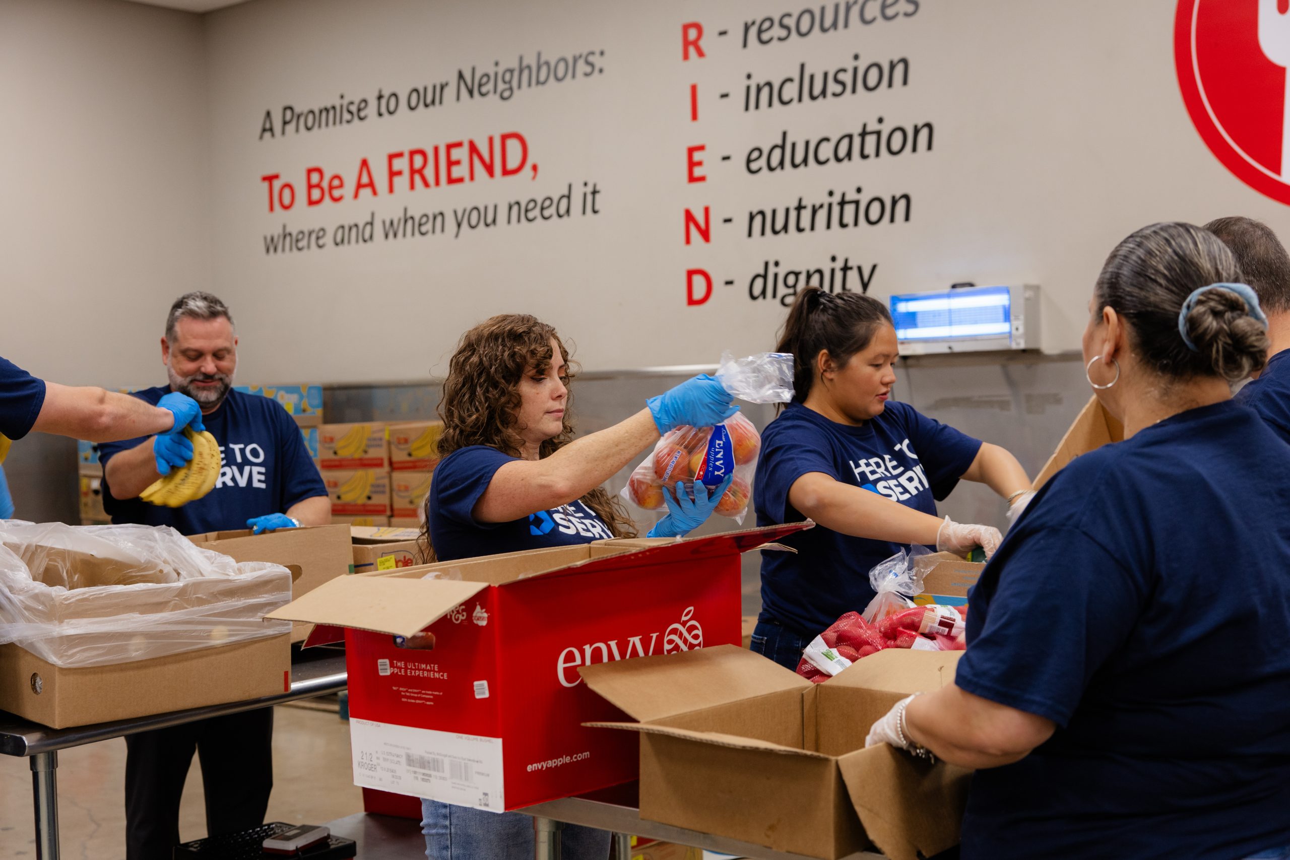 DOCUmation team members volunteering at a community food bank sorting and packing fresh produce