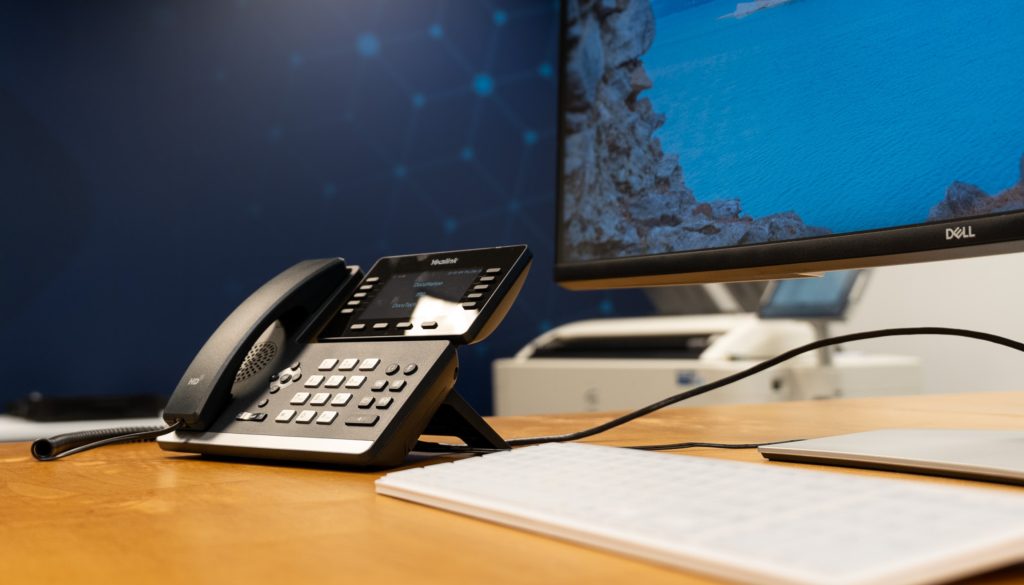 VoIP business desk phone and workstation setup in a DOCUmation office environment